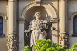 Diosa de la Justicia entre pilares, representando los valores de Montiglio y Asociados Abogados: personalización, empatía y transparencia
